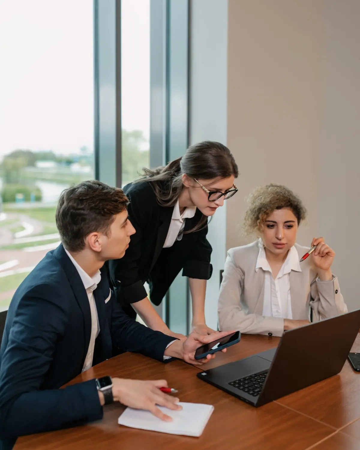 A meeting around a laptop in a bright office